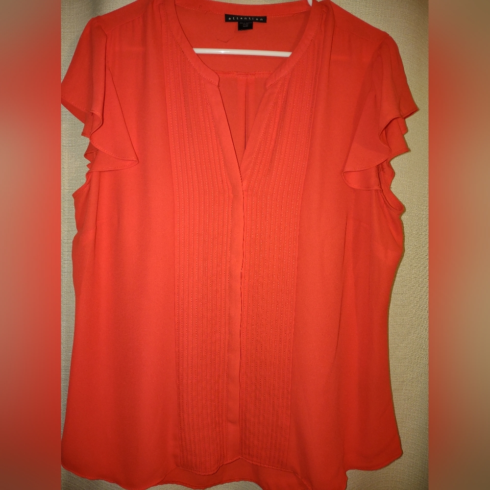 Attention pretty orangish color short sleeve blouse with flowing on the bottom.